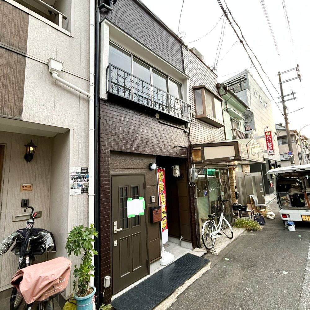 こげ茶の外壁塗装で重厚感を出したリノベーション後の長屋外観