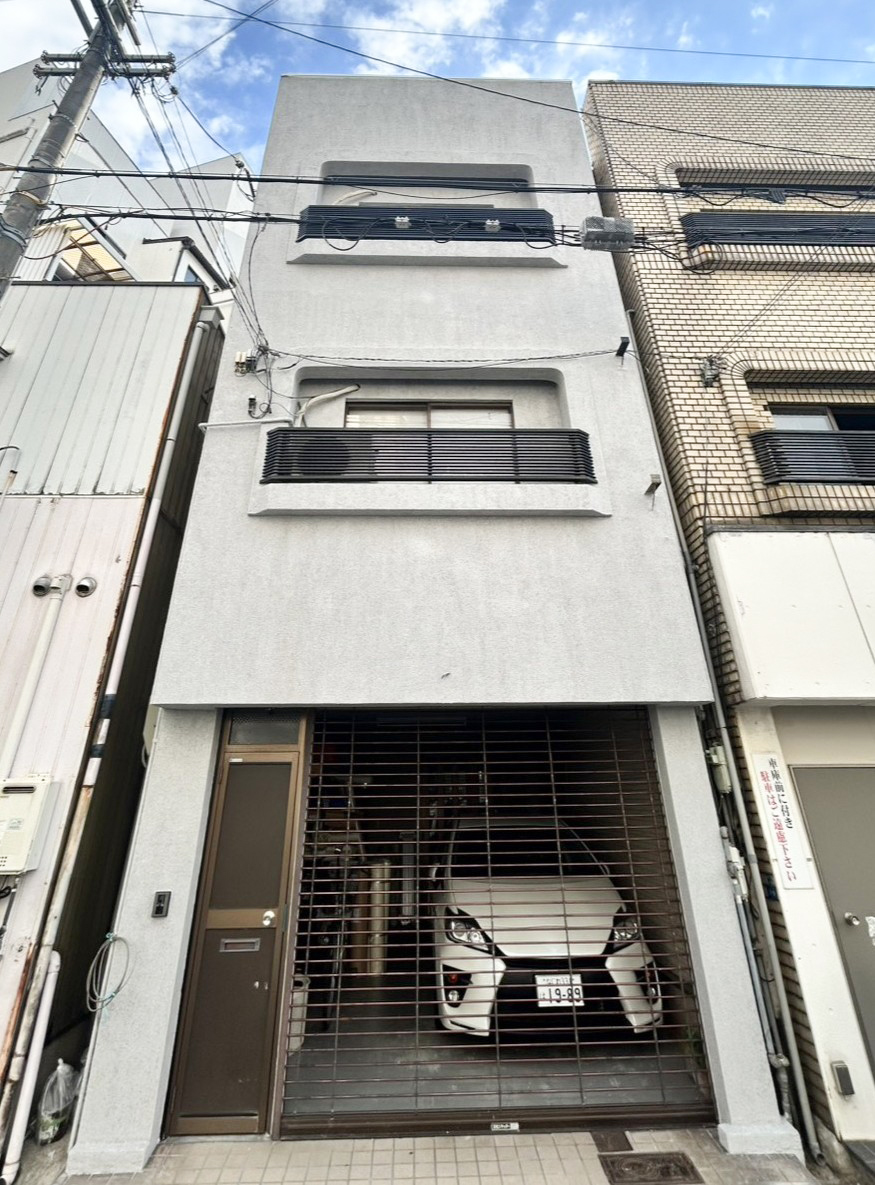 塗装仕上げに一新した3階建て戸建ての外壁全景。タイルを撤去しグレー基調のシックな外観に仕上げた正面（大阪市東住吉区・施工後）