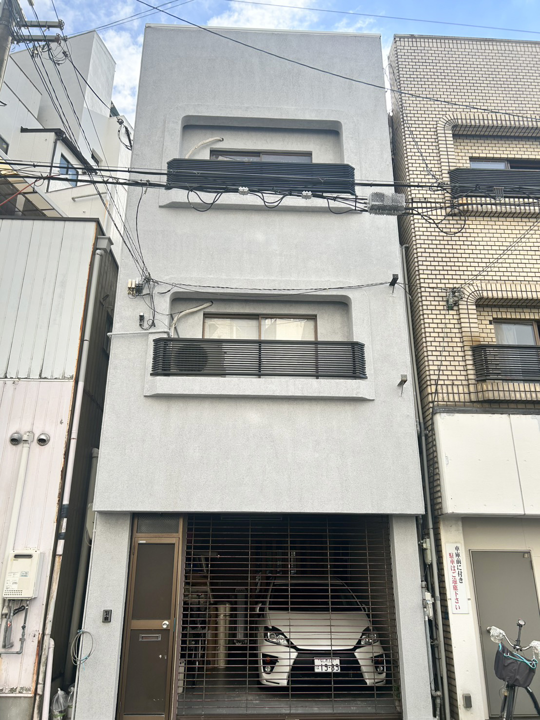 グレー基調に塗り替えた3階建て戸建ての外壁正面。タイルを撤去し塗装仕上げでシックに一新した全景（大阪市東住吉区・施工後）