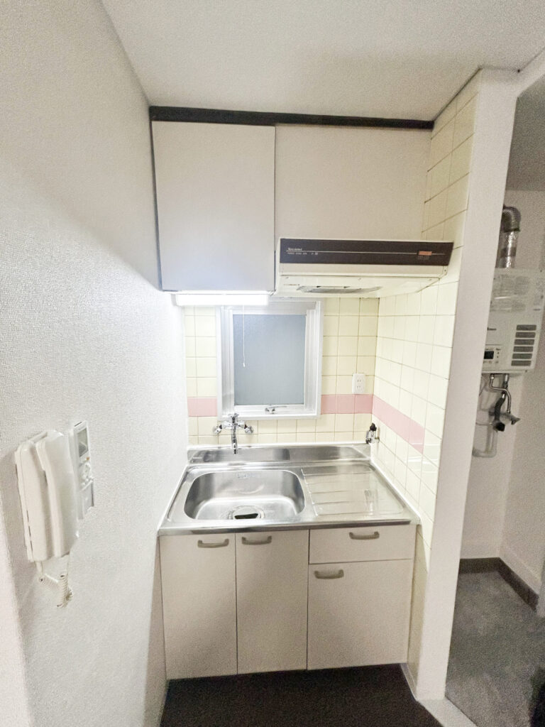施工後のミニキッチン。扉をリアテックで白く貼り替え、水栓と手元灯も交換したキッチン（大阪市浪速区）